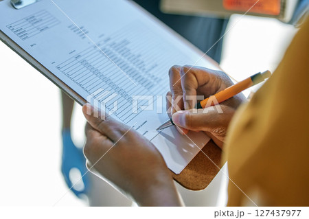 Closeup, clipboard and woman writing for delivery, ecommerce and logistics for sales service. Invoice checklist, customer signature and shipping product to client in home for e commerce supply chain 127437977