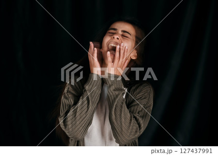 Woman with anxiety, crying and bipolar for crazy psychology on black studio background. Girl with trauma, schizophrenia and mental health shouting for fear Woman with anxiety, crying and bipolar for crazy psychology on black studio background. Girl with trauma, schizophrenia and mental health shouting for fear 127437991