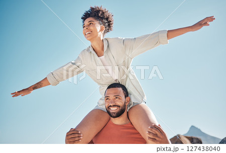 Love, happy and piggyback with couple and blue sky in nature for freedom, support and summer. Smile, vision and airplane with woman on man shoulders for vacation, bonding and affection together 127438040