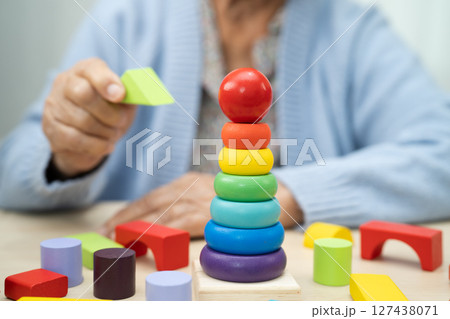 Alzheimer disease AD, Asian elderly woman patient suffering from dementia learn practical motor skills rehabilitation. Alzheimer disease AD, Asian elderly woman patient suffering from dementia learn practical motor skills rehabilitation. 127438071