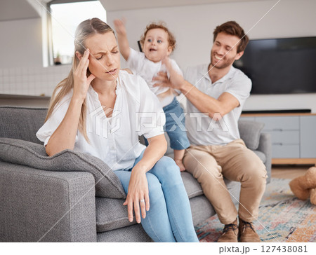 Family, stress and headache of mother on sofa with father, hyper active energy and adhd child. Tired, burnout and woman in living room with boy and dad feeling depression or anxiety in home with kid. 127438081