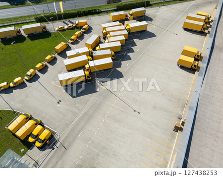 Delivery vans and trucks hub. Fleet of yellow post vehicles. 127438253