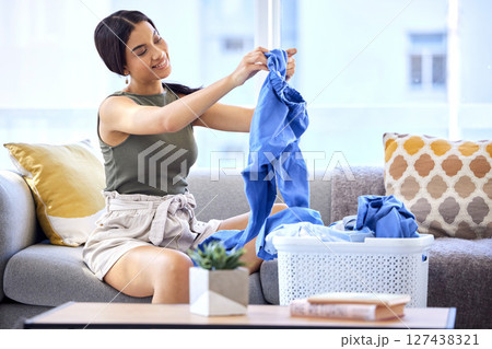 Cleaning, laundry and folding clothes with woman in living room for housekeeping, fresh and tidy. Fabric, washing and basket of linen with cleaner on sofa at home for household, chores and domestic Cleaning, laundry and folding clothes with woman in living room for housekeeping, fresh and tidy. Fabric, washing and basket of linen with cleaner on sofa at home for household, chores and domestic 127438321
