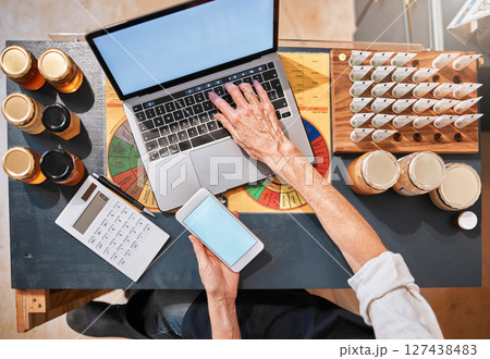 Hands, laptop and honey with a retail woman checking her phone while working at a desk in her store. Computer, ecommerce and email with a female employee typing a text message at work in her startup 127438483