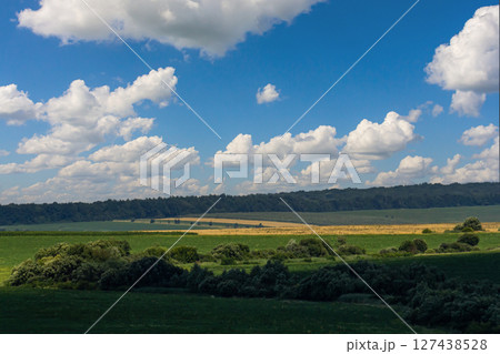 Cloud formation resembling a heart shape over a green landscape during daytime in the countryside Cloud formation resembling a heart shape over a green landscape during daytime in the countryside 127438528