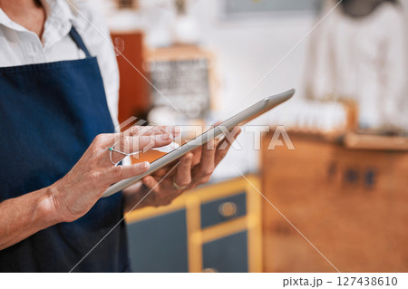 Hands, tablet and small business owner woman with e commerce, stock supply chain management and marketing for cafe. restaurant, barista and worker typing on digital technology or software network app 127438610