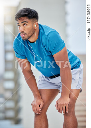 Tired, fitness and sweat with earphones music for cardio, workout and athletic training break. Exercise, exhausted and sweaty indian man listening to audio streaming on outdoor athlete rest. Tired, fitness and sweat with earphones music for cardio, workout and athletic training break. Exercise, exhausted and sweaty indian man listening to audio streaming on outdoor athlete rest. 127438966