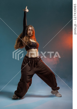 Jazz-funk dancer in fierce pose with dramatic lighting and smoke, radiating power, rhythm, and urban style. Jazz-funk dancer in fierce pose with dramatic lighting and smoke, radiating power, rhythm, and urban style. 127439065