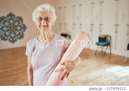Yoga, mat and portrait of a senior woman in a wellness studio for an exercise or meditation class. Happy, smile and elderly female in retirement at mind and body pilates workout for peace and balance Yoga, mat and portrait of a senior woman in a wellness studio for an exercise or meditation class. Happy, smile and elderly female in retirement at mind and body pilates workout for peace and balance 127439122