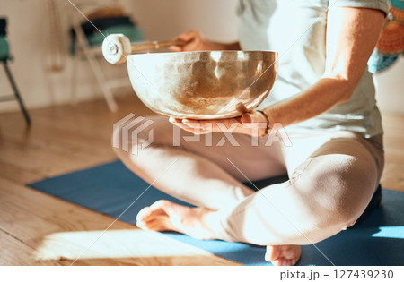 Yoga, tibetan bowl and hands of woman in meditation, sound therapy and healing with zen, ambient and peace on a floor. Wellness, singing bowl and lady practice mind, energy and inner peace in India 127439230