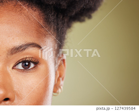 Beauty, black woman and half face portrait for dermatology, facial or skincare advertising. Wellness, health and natural skin cosmetic zoom of model with green studio mockup for marketing. Beauty, black woman and half face portrait for dermatology, facial or skincare advertising. Wellness, health and natural skin cosmetic zoom of model with green studio mockup for marketing. 127439584