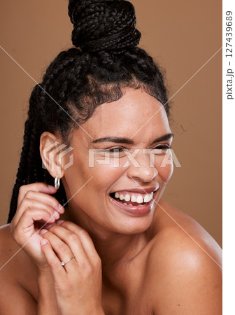 Makeup, marketing and woman laughing for cosmetics, skincare and self care against a brown studio background. Relax, comic and model with comedy from beauty, dermatology and advertising of body glow 127439689