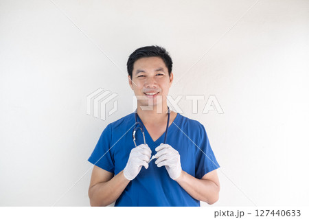Smiling Asian Male Nurse in Scrubs with Gloves and Stethoscope 127440633
