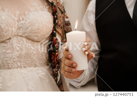 Romantic Wedding Unity Candle Lighting Ceremony: Couple Holding Lit White Pillar Candle, Lace Gown, Formal Attire, Soft Focus, Intimate Moment 127440751