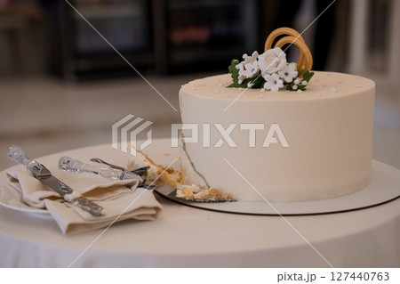 Elegant Wedding Cake with White Floral Decoration on Round Table, Light Beige and Cream Color Palette, Celebration and Dessert Theme. 127440763