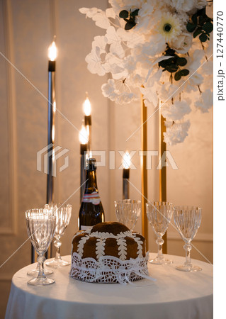 Elegant Wedding Table Setting with Cake, Champagne, and Candles: Warm Gold Tones, Rustic Romance and Intimate Celebration Atmosphere. Elegant Wedding Table Setting with Cake, Champagne, and Candles: Warm Gold Tones, Rustic Romance and Intimate Celebration Atmosphere. 127440770