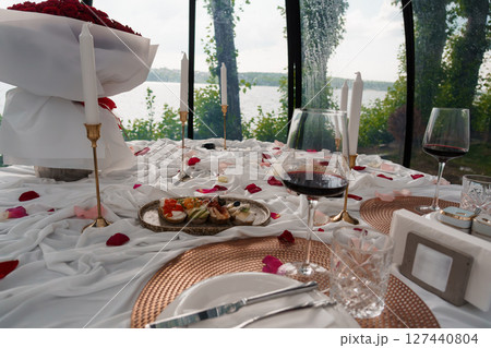 Romantic Lakeside Dinner for Two: Roses, Wine, Candles and Cozy Atmosphere at a Glass House with Water View 127440804