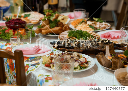 Lavishly Set Traditional Feast Table: Abundant Ukrainian Cuisine, Colorful Dishes, Festive Dinner, Family Gathering, Dark Wood, Vibrant Textiles. Lavishly Set Traditional Feast Table: Abundant Ukrainian Cuisine, Colorful Dishes, Festive Dinner, Family Gathering, Dark Wood, Vibrant Textiles. 127440877