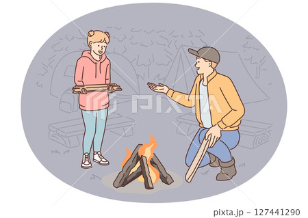 Father and daughter make fire together during family camping trip and enjoy trip to nature together 127441290