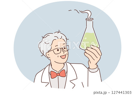 Laboratory assistant holds flask with green fuming liquid while examining chemical reaction Laboratory assistant holds flask with green fuming liquid while examining chemical reaction 127441303