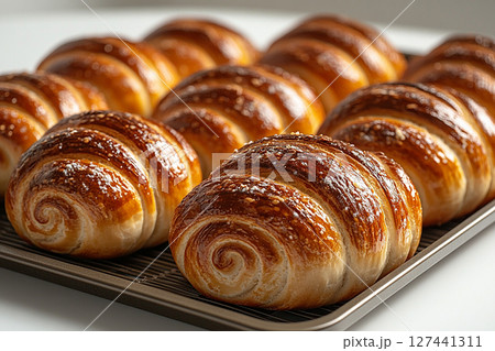 Comfort food.  Variety of baked snail-shaped buns in on a wooden trading tray on a white background. 127441311