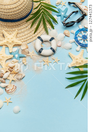 Summer vacation accessories creating a frame on blue background Summer vacation accessories creating a frame on blue background 127441373