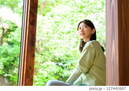 女性が縁側に座り穏やかな表情で緑を見つめる静かな夏のひととき 女性が縁側に座り穏やかな表情で緑を見つめる静かな夏のひととき 127442007