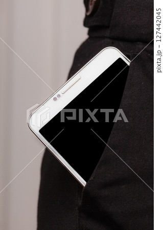 Mobile phone in trousers pocket showing. 127442045