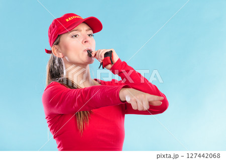 Lifeguard woman in cap on duty blowing whistle. Lifeguard woman in cap on duty blowing whistle. 127442068