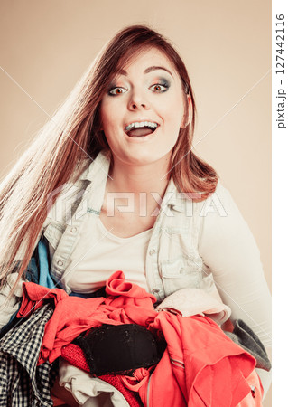 Smiling girl hold pile of clothes. Smiling girl hold pile of clothes. 127442116