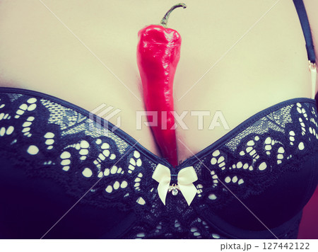 Woman wearing lingerie holding chilli pepper 127442122