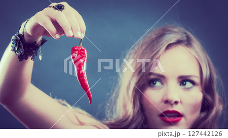 Woman wearing lingerie holding chilli pepper Woman wearing lingerie holding chilli pepper 127442126