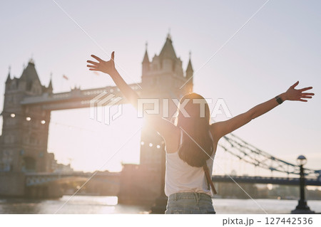 Woman, freedom and travel by the London bridge or city for holiday break or outdoor summer vacation. Joyful female tourist with open arms enjoying sunny adventure trip, traveling and sightseeing Woman, freedom and travel by the London bridge or city for holiday break or outdoor summer vacation. Joyful female tourist with open arms enjoying sunny adventure trip, traveling and sightseeing 127442536