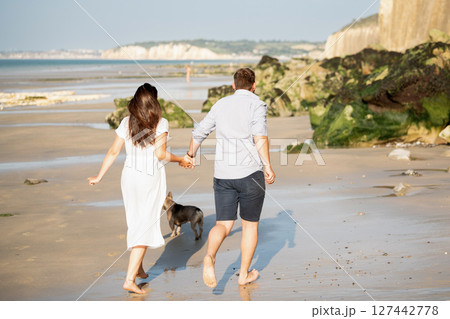 Back view of a couple running on the ocean 127442778