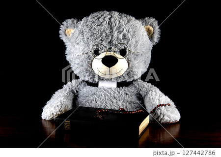 Teddy Bear Dressed as Catholic Priest with Bible and Rosary on a Black Background Teddy Bear Dressed as Catholic Priest with Bible and Rosary on a Black Background 127442786
