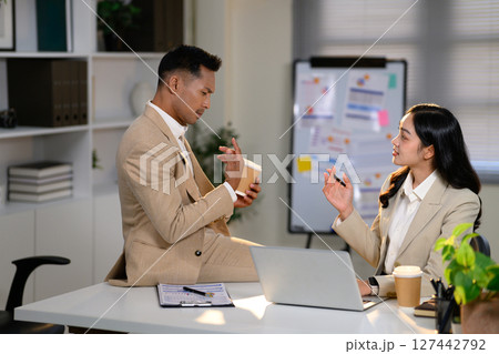 Colleagues exchanging ideas and working on a project in a contemporary workspace 127442792