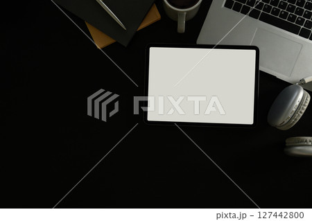 Top view of digital tablet, laptop, headphones, and coffee on black background 127442800