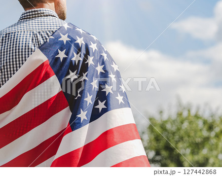 Attractive man holding American Flag. Close-up, outdoors 127442868