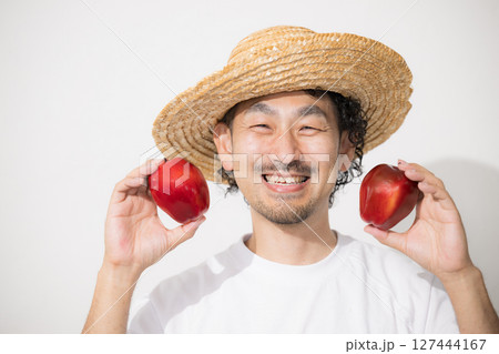 収穫したりんごを持つ男性のイメージ カメラ目線の笑顔 農家や農業のイメージ 収穫したりんごを持つ男性のイメージ カメラ目線の笑顔 農家や農業のイメージ 127444167