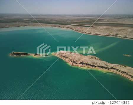 Aerial: elongated desert island in Kuimazar Reservoir, Uzbekistan 127444332
