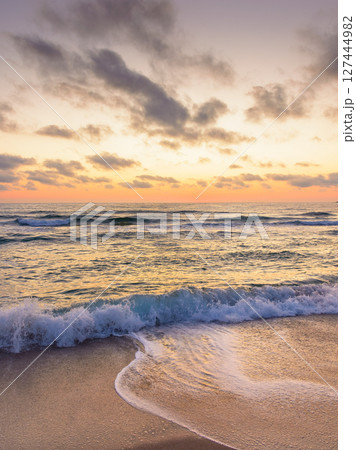 sea wave touch the sand beach at dawn. summer vacations in sozopol. nature after tranquil dream under glowing orange sky with dark clouds. scenic view of a seascape with calm water and relax mood sea wave touch the sand beach at dawn. summer vacations in sozopol. nature after tranquil dream under glowing orange sky with dark clouds. scenic view of a seascape with calm water and relax mood 127444982