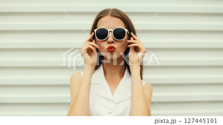 Fashion portrait of beautiful young woman blowing a kiss in white glasses, stylish girl posing Fashion portrait of beautiful young woman blowing a kiss in white glasses, stylish girl posing 127445191