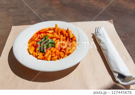 Penne arrabiata - traditional italian pasta with spicy sauce on a table 127445678