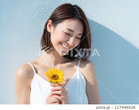 ひまわりを持つ笑顔の女性 127446026