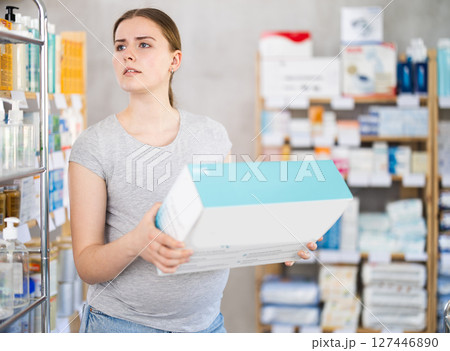 Pregnant woman chooses a sterilizer for bottles at pharmacy Pregnant woman chooses a sterilizer for bottles at pharmacy 127446890