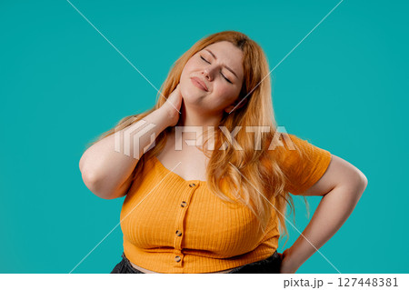 Tired plus size woman feeling pain in neck joint, massaging muscles,rubbing head 127448381