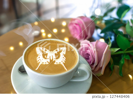 Close-up shot of a cappuccino with rose latte art in a white cup on a saucer 127448406