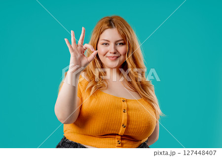 Body positive woman OKAY sign, ok gesture. Happy lady, correct choice, blue wall 127448407