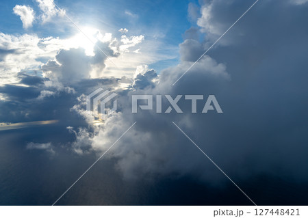 Dramatic sky with sunbeams and clouds seen from an airplane Dramatic sky with sunbeams and clouds seen from an airplane 127448421