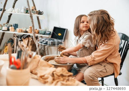 Creative process. Mother with little girl doing pottery at home 127448693